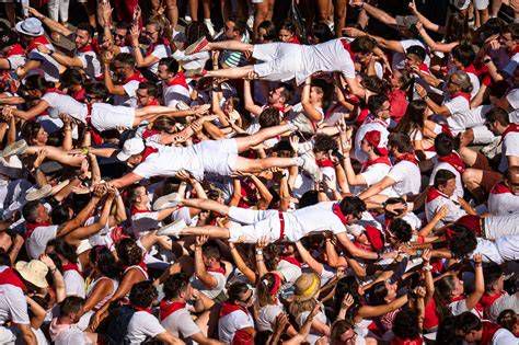 Participantes de una fiesta tradicional en Bayona con vestimenta roja y blanca