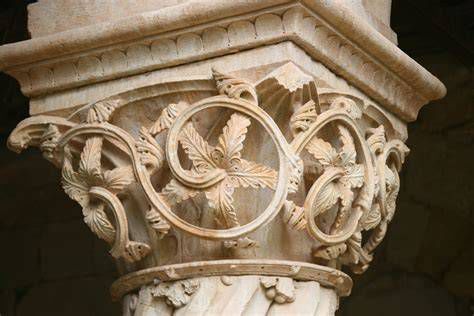 Detalle escultórico del paraíso con capiteles tallados y fuente en el centro