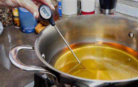 Termómetro de cocina controlando la temperatura del aceite para freír