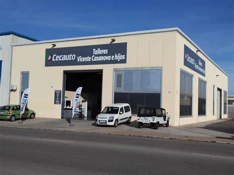 fachada taller mecánico con furgonetas y señalización