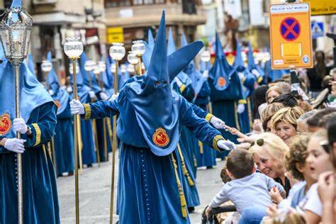 nazarenos y tronos en procesión del Viernes de Dolores