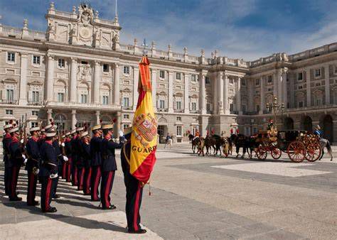 Guardia real interpretando toque de oración junto a la bandera a media asta