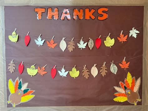 Niños realizando mural de acción de gracias con hojas de otoño