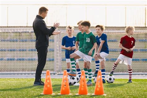 Entrenador instruyendo a jóvenes jugadores en entrenamiento de fútbol