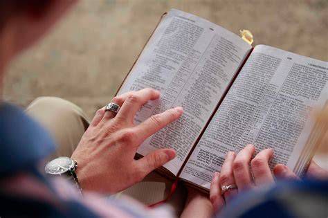 Persona leyendo la Biblia y tomando notas para orar