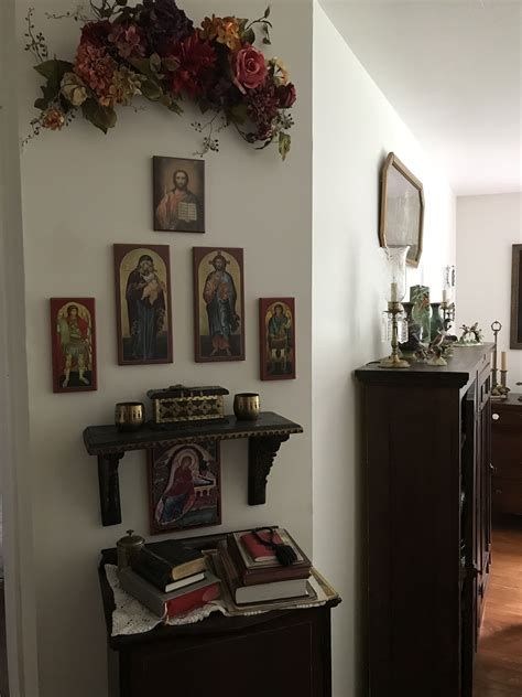 Iconos religiosos sobre estantería de madera en rincón de oración