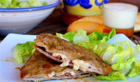 Plato de cachopo con queso y pimientos asados