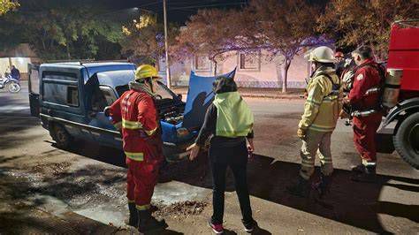 Intervención de bomberos extrayendo ocupantes de vehículo en calle urbana
