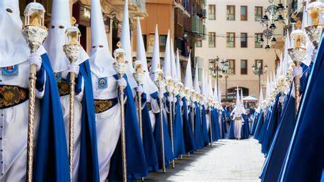 Procesión de Semana Santa en calles estrechas de pueblo con banda de tambores