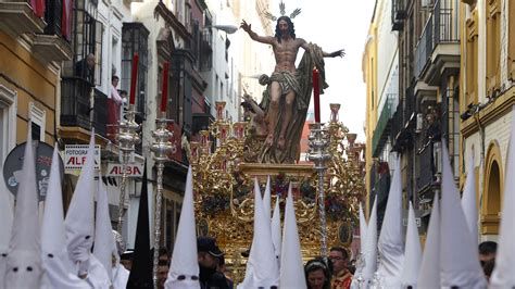 Procesión de Semana Santa en Sevilla con nazarenos y pasos de Cristo Resucitado