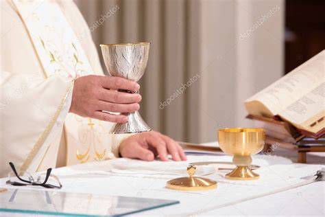 Manos de sacerdote sosteniendo un cáliz y un rosario