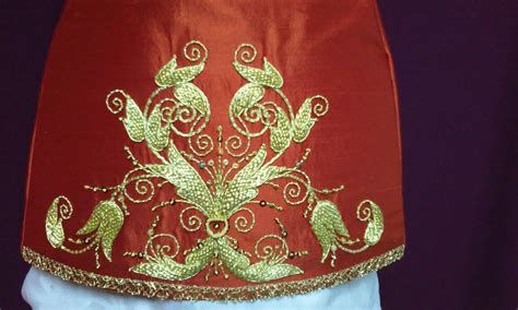 túnicas bordadas en oro sobre terciopelo rojo