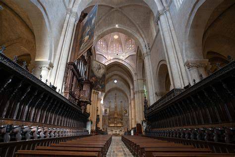 Interior de la catedral: naves y pilares con cuadros de apóstoles