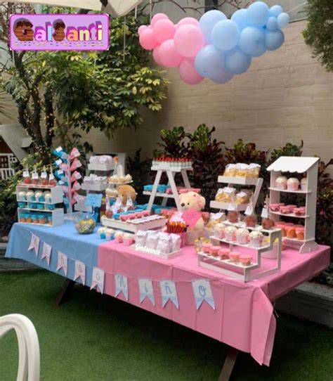 Ejemplo de mesa dulce temática revelación de género con globos y dulces en tonos rosa y azul