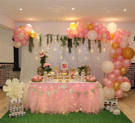 Mesa dulce elegante con globos dorados y bandejas espejadas
