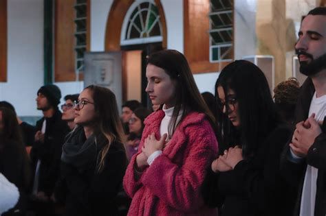 Grupo de jovens cantando na igreja de Taizé com velas