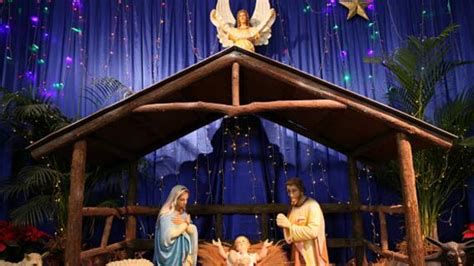 Familia rezando alrededor del pesebre en Nochebuena