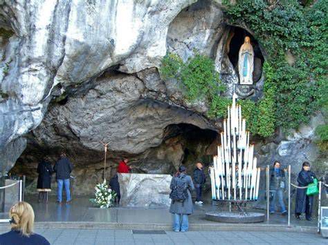 Gruta de Massabielle en Lourdes, peregrinos junto al manantial