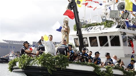 procesión marítima con barcos engalanados y lanzamiento de ramos