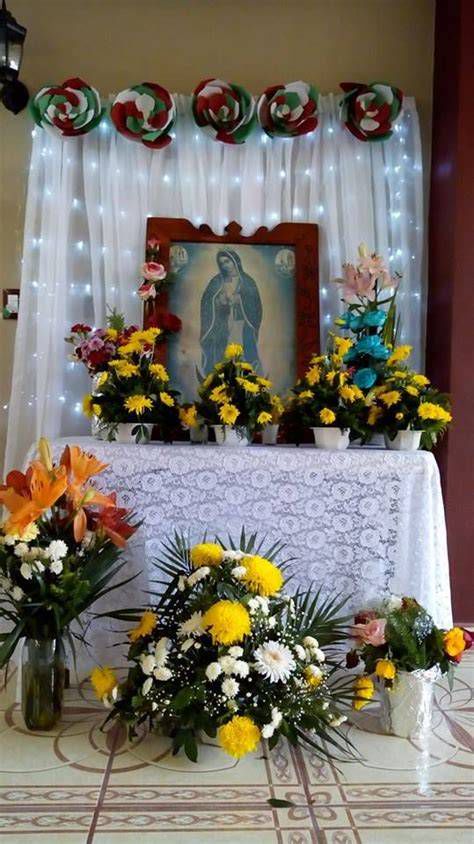 altar casero con imagen de la Virgen de Guadalupe, velas y flores