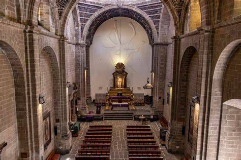 Foto del interior del templo de una parroquia de Granada con feligreses en misa